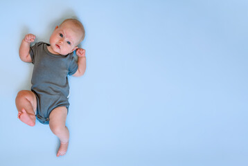 Portrait of a cute funny Caucasian baby on a blue background. Place for text, copy space