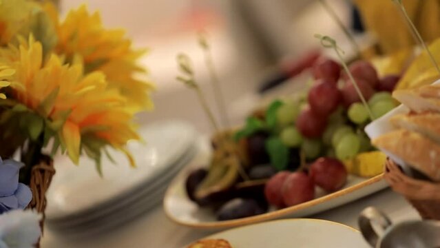 Ukrainian festive table in the national serving, decoration with sunflowers. Grapes on the table, people have dinner.
