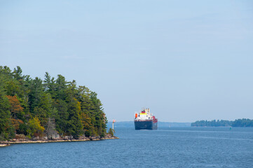 Large cargo ship plying through the St Lawrence River in fall