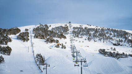 People, adults and kids, skiers and snowboarders going up on chairlift. Ski winter holidays in...