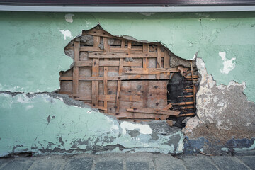 Abandoned building wall exterior with hole on concrete facade. Renovation and maintenance concept.