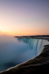 Fototapeta premium Sunrise over Horseshoe Falls closeup in the morning with mist at Niagara Falls in Canada, slow shutter speed, long exposure