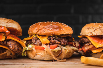 Traditional American smash burger with cheddar cheese,  tomato, grilled onions and lettuce with a side of fries.