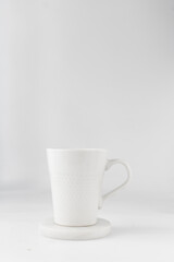 white ceramic cup on a white marble saucer, white teacup	