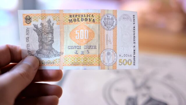Man holding a 500 Moldova Lei note currency
