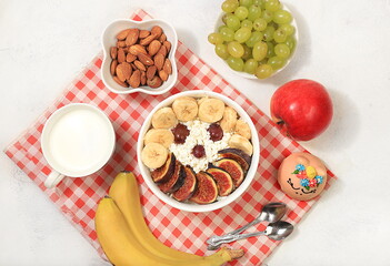 Healthy breakfast with ingredients, fun food for kids. The concept of healthy and natural food. Cottage cheese with figs and bananas, nuts and grapes, top view,