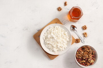 Healthy breakfast with ingredients, fun food for kids. The concept of healthy and natural food. Cottage cheese with muesli and honey, nuts