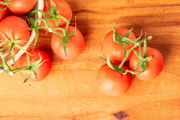 Tomatoes, beautiful details of fresh red tomatoes on branches over rustic wood, top view.
