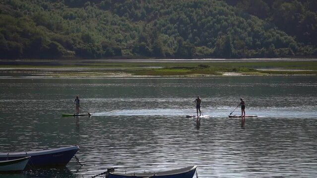 Familia feliz montada en paddle surf disfrutando del verano