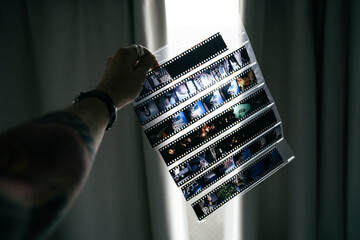 Tattooed arm holding a sheet of reversal film