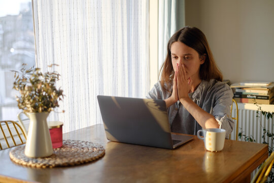 Stressed woman working on laptop from home