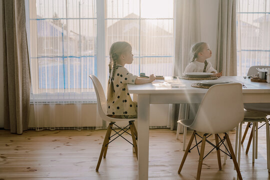 Two girls sitting at a dining table 