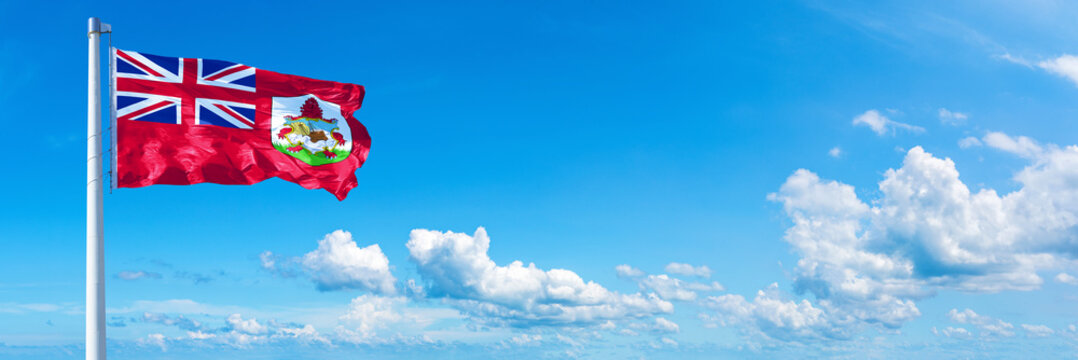 Bermuda flag waving on a blue sky in beautiful clouds - Horizontal banner