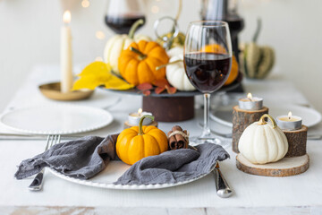 Idea for a beautiful autumn setting for thanksgiving family dinner or wedding. Orange pumpkin as decor. Cozy fall home atmosphere.