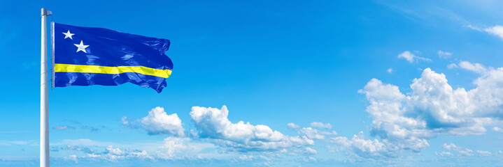 X flag waving on a blue sky in beautiful clouds - Horizontal banner