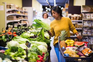 Obraz premium Casual woman doing shopping in grocery department of supermarket