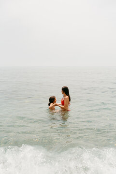 Mother and daughter inside the cold water in the Mediterranean Sea 