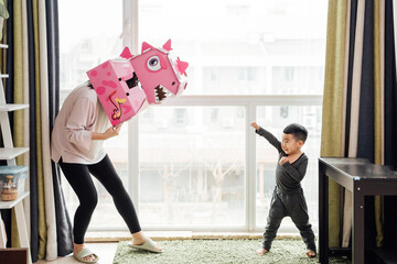 Little boy and his mother playing at home