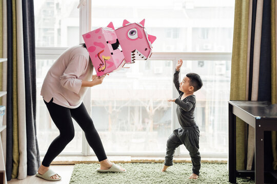 Little boy and his mother playing at home