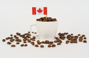 The flag of Canada sticks out of a cup of roasted coffee beans.