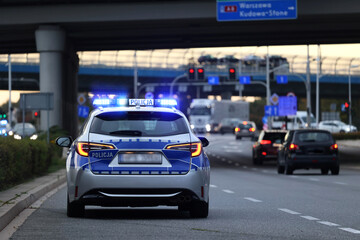 Polscy policjanci i ich pojazdy podczas wieczornej służby w mieście.