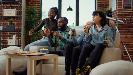 Competitive sports fans watching football match game on tv channel, showing support with soccer...