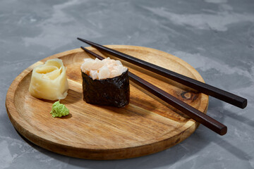 Warm rolls with tuna, salmon, perch, eel, tobiko caviar, nori, rice, cucumber on black background.