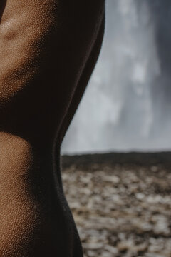 Close-up naked woman's back by the waterfall in Iceland