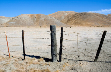 Barbed wire fence gate in the California desert. - 537915535