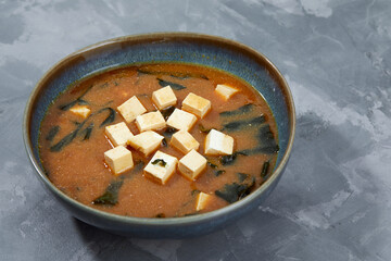 Japanese miso soup in a gray bowl on the black table. horizontal view from above