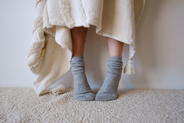 Beautiful female legs in cozy knitted socks close-up. Warm socks for cold weather
