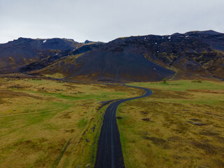 Nice aerial landscape road and field with moss clouds and mountain