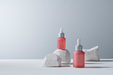 Transparent cosmetic bottle with pipette on natural stone