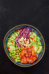 Top view on poke salad with tuna and green vegetable in the bowls on gray background. Copy space.