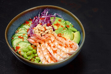 Top view on poke salad with red shrimps and green vegetable in the bowls on gray background. Copy space.
