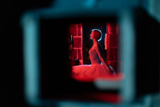 Young girl ballerina posing in red light