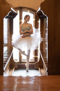 Young girl with short blonde hair standing like ballerina