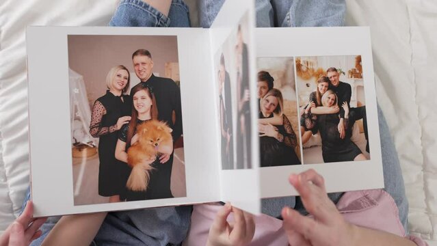 top view. flip through a photobook with photos of a family photo shoot