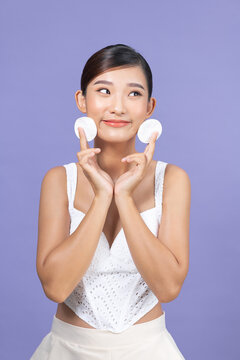 Portrait of young beautiful woman with cotton pads cleaning her face