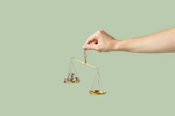 Coins weighed on scales in woman's hand.