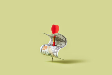 Dollar bill pinned by red dart.