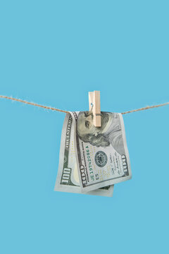 Hundred dollar banknote hanging on rope.