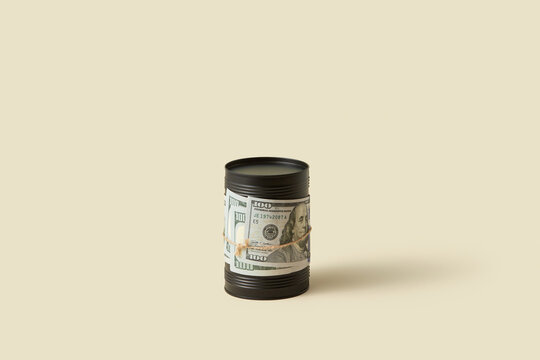 Dollar bill tied around black oil barrel.