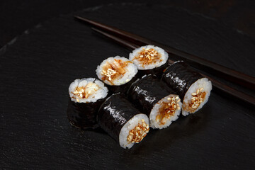 Traditional delicious freshsushi rolls with shrimp on a black background. Sushi roll with rice, cream cheese, avocado, salmon, sesame. Sushi menu. Japanese kitchen, restaurant