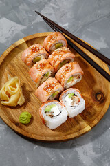 Traditional delicious freshsushi rolls with shrimp on a black background. Sushi roll with rice, cream cheese, avocado, salmon, sesame. Sushi menu. Japanese kitchen, restaurant