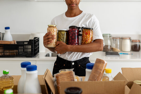 Female volunteer holding canning jars in kitchen