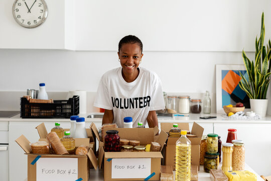 Volunteer with food boxes in kitchen