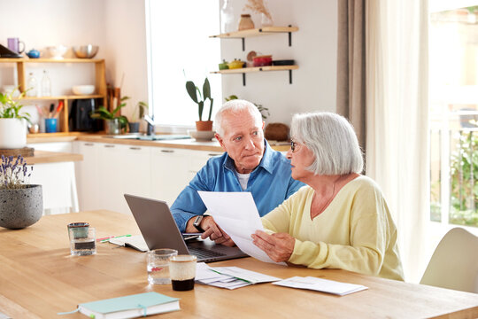 Concerned elderly couple paying taxes
