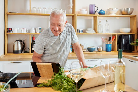 Mature man searching for recipe on tablet