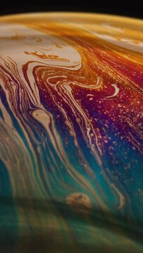 Vertical video fluid soap bubble looking like planets. Psychedelic colorful abstract art with urreal patterns of color in motion.